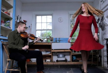 musicien et danseuse iralndais dans leur cuisine en train de jouer et danser