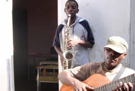 Un guitariste et au 2ème plan un joueur de saxophone