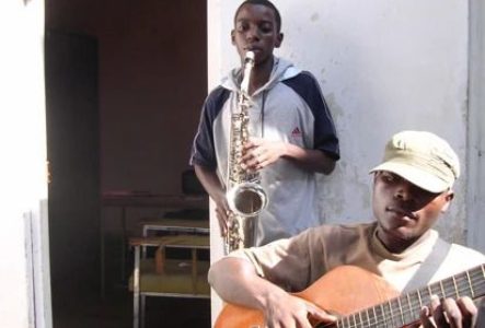 Un guitariste et au 2ème plan un joueur de saxophone