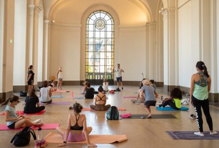 Groupe de personnes faisant du sport dans la cour du musée