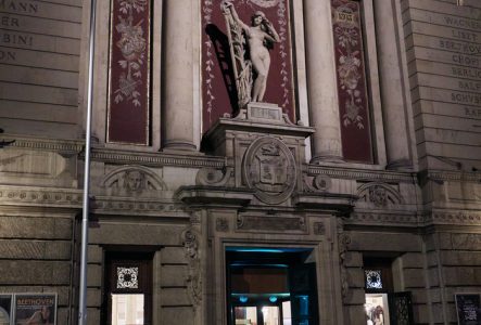 Photo de l'entrée du Victoria Hall de nuit avec du public