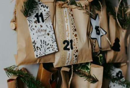 Paquets cadeaux en papier suspendus à une guirlande de fil et de branches de pin