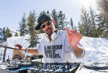 Un portrait de Dj Greens en train de mixer en station de sports d'hiver.