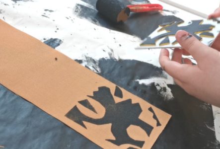 Photos rapprochées de mains d'enfants qui tamponne une forme sur un tissu