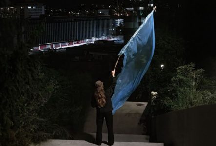 Eve Chariatte, NIGHT WALK, personne de dos brandissant un drapeau