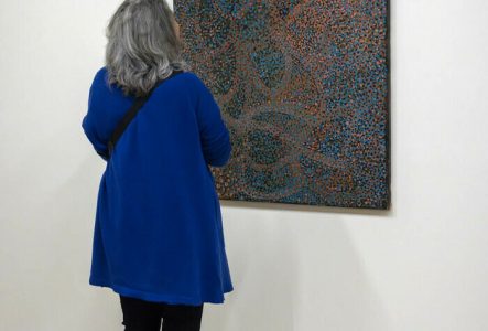 Photo de personnes devant une oeuvre de l'exposition