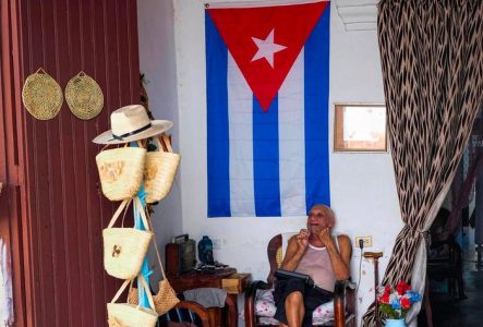 Un homme assis sur une chaise dans ce qui semble être sa maison
