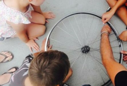 DR Des enfants regardent une roue de vélo au sole. Ils et elles vont la transformer en instrument de musique.