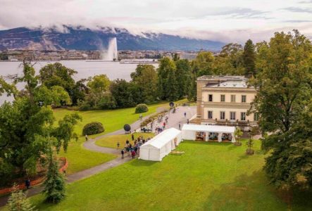 Julien Gaspoz Des tentes de festival avec des gens devant le Musée d'Histoire des Sciences de la ville de Genève, au bord du lac Léman.