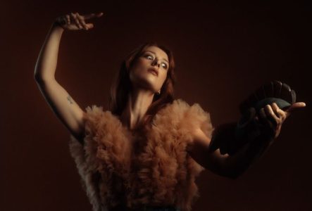 Photo de Grace Cummings, mise en scène artistique avec une pose sculpturale, rappelant un tableau clair-obscur.