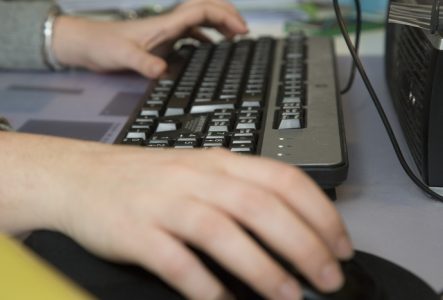 D.Baumann Un clavier et des mains sur le clavier en gros plan
