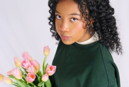 Une photo de l'artiste tenant un bouquet de tulipes
