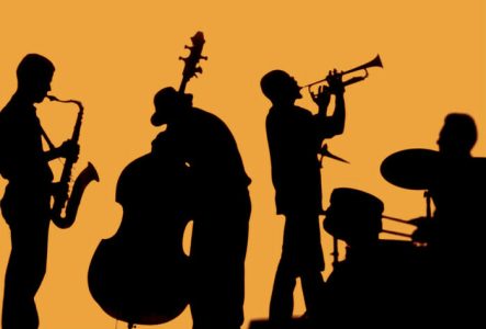 Silhouettes noires de musiciens sur fond orange