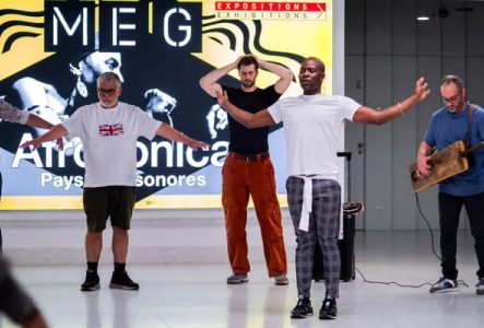 Un groupe de personnes dansent dans une salle du MEG.  Un musicien gnawa donne le tempo