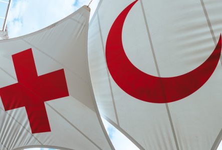 Deux grands drapeaux, l'un avec une croix rouge et l'autre un croissant rouge sur fond blanc