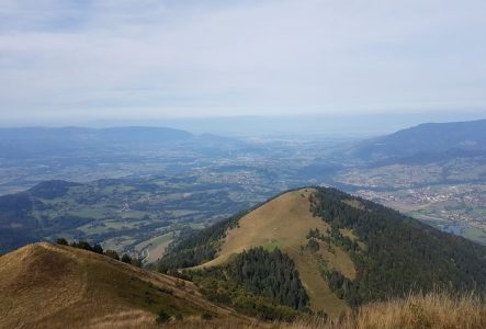 une photo en couleur prise depuis le sommet d'une montagne, vue sur la vallée.