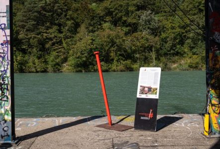 Clou Rouge et panneau explicatif avec le Rhône en arrière-plan
