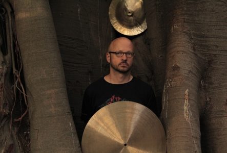Christian Wolfarth dans un arbre avec ses cymbales