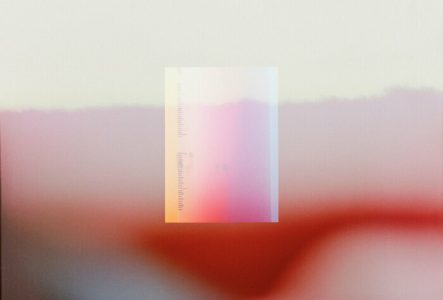 Photographie en couleur floue, montrant un paysage de montagne sur lequel est superposé, en transparence, une courte règle graduée.