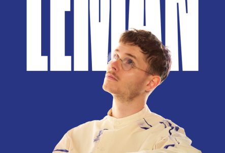 Affiche du concert de Léman. Portrait du chanteur de face, portant un pull noir et des lunettes rondes, regard baissé. Fond beige clair avec le prénom « LÉMAN » écrit en grandes lettres blanches derrière lui. Mention « En tournée » en bas à droite.