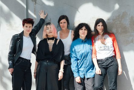 ©Lynn SK Photo des 5 membres du groupe qui posent debout devant un mur
