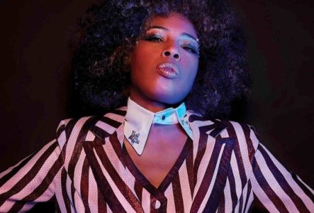 Portrait de Macy Gray habillée d'une blouse rayée brun et blanc