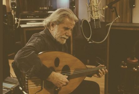 Photo de Marcel Khalifé assis sur une chaise en train de jouer du oud