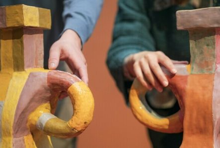 Deux personnes touchent la surface d’œuvres en céramique dans l'exposition "Marie Ducaté. Simultanés"
