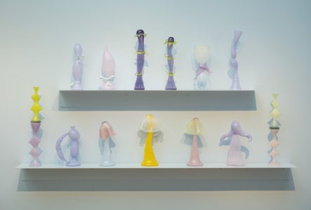 Vue de l'exposition : on y voit des vases en verre aux couleurs pastels