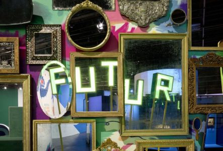 Photo de miroirs sur un murs coloré dans lesquels se reflètent le mot futur