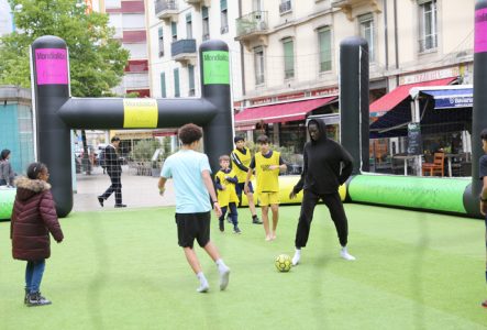 Enfants jouant au foot sur un terrain.