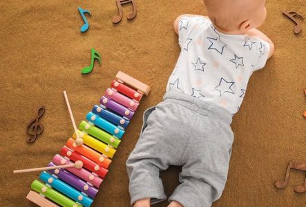 Un bébé à côté d'un xylophone coloré