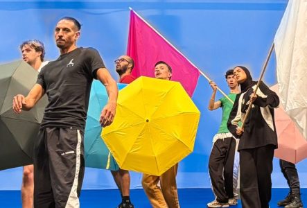 Jeunes gens rassemblés avec drapeaux et parapluies de couleurs différentes