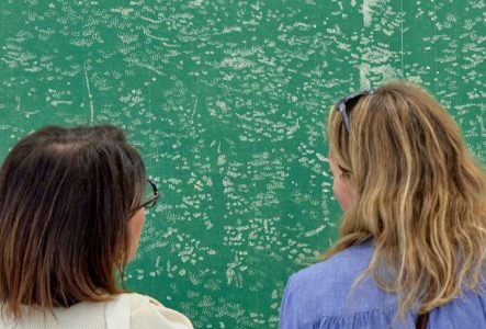 Deux personnes regardant un tableau aux tonalités vertes