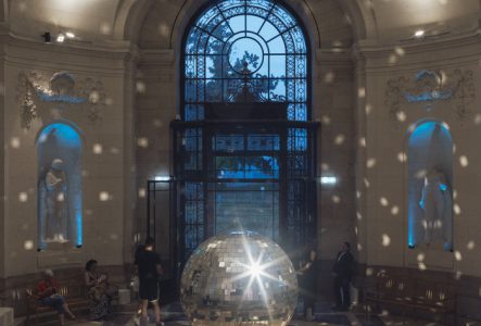 Public dans le hall du musée autour d'une boule à facettes