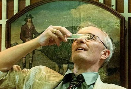 Sur cette image, On peut y voir un homme d'un certaine âge observant une règle transparente.