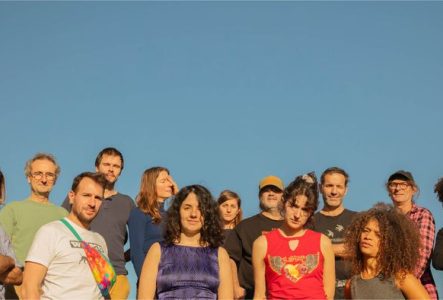 Un groupe de 13 personnes sur un ciel bleu.