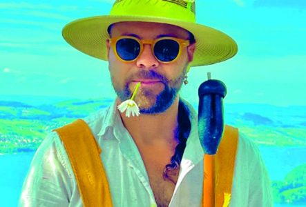 Un portrait coloré et flamboyant de Papaya Tropical avec une étendue d'eau en arrière plan.