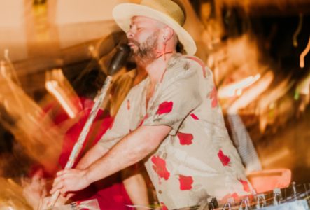 Un portrait coloré et flamboyant de Papaya Tropical avec une étendue d'eau en arrière plan.