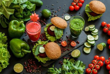 DR Une photo en couleur qui représente des poivrons, des tomates, des jus de légumes vert et rose et des sandwiches