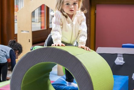 petite fille jouant avec un anneau dans une ludothèque