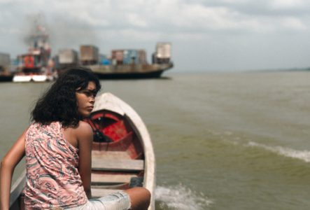 Une fille seule sur un petit bateau, elle regarde en arrière