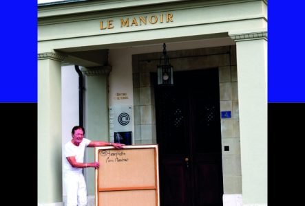 Affiche de l'exposition avec un portrait en pied de l'artiste tenant une toile (vue de dos) devant l'entrée du Manoir de Cologny