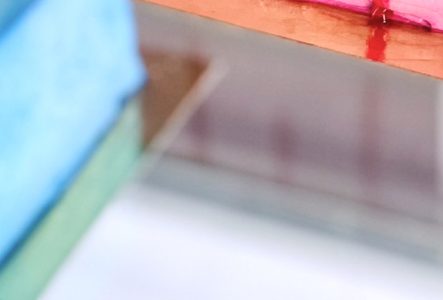 C'est un part de gateau sur une vitrine. Avec un coulis de fruits rouge, le gateau est rose.