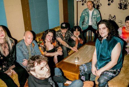 Un groupe de musique assis dans un bar autour d'une table. Il y a 9 personnes.