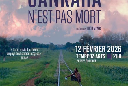 Un homme assis sur des rails qui n'ont pas l'air d'être souvent utilisés