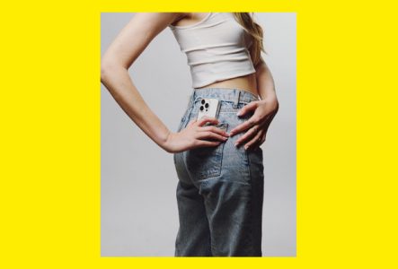 Photo d'une personne de dos avec un téléphone sortant de la poche arrière de son pantalon