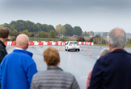 groupe de personnes et instructeur analysant la conduite d'un participant sur la piste de conduire lors d'un ateliers de conduite seniors