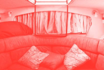 L'intérieur d'un van. On voit comme un canapé et des coussins. La photo est en filtre couleur.