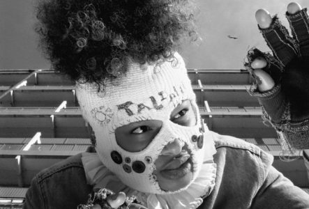 DR Photo en noire et blanc de la rappeuse, qui porte une cagoule en laine qui lui cache le visage à l'exception des yeux et de la bouche
